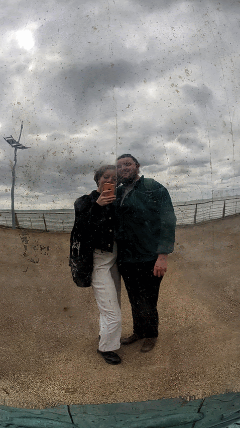 Couple taking a selfie in a distorted reflective surface